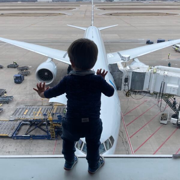 Boy looking out window at airplane.